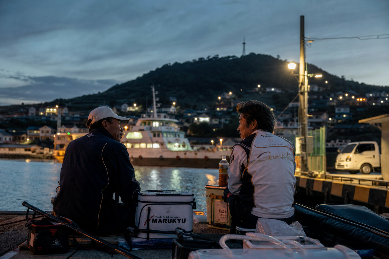 premium coastal island scene on Yokjido, anglers resting near a harbor after sunset with warm harbor lamps, subtle sea breeze, ferry and village lights in background, realistic travel editorial photography, layered depth, natural skin tones