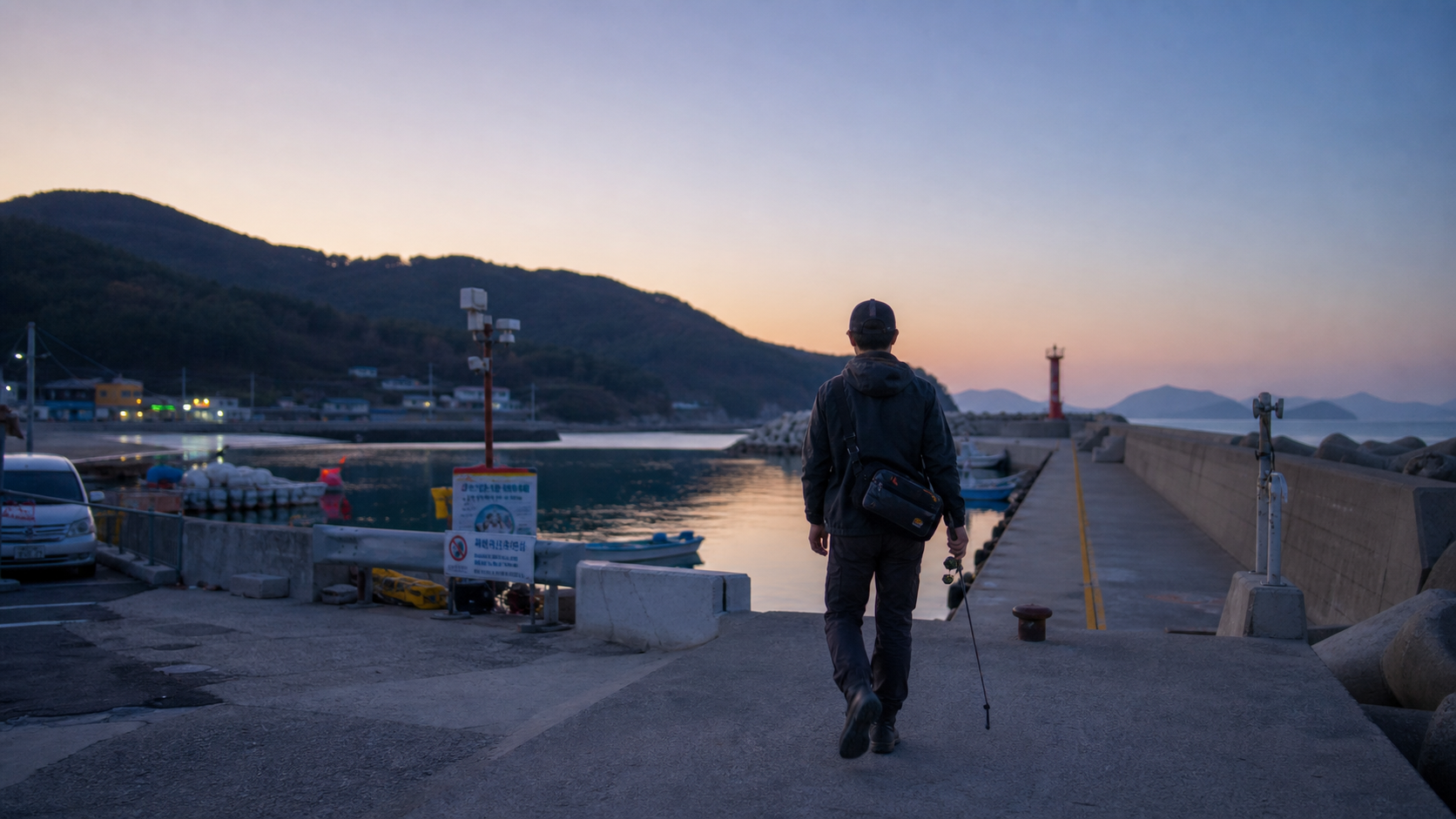(Documentary shore eging scene on Geoje west coast, beginner angler walking from a small harbor parking lot to a clean concrete breakwater at sunrise, compact eging rod and sling bag, calm inner-bay water, village lights fading, realistic Korean fishing harbor details, 35mm lens, natural blue-orange dawn light, editorial outdoor mood --ar 16:9) 거제도 서부권 초행 출조의 첫 장면. 큰 장비보다 가벼운 워킹과 마을형 어항 분위기가 느껴지도록 구성합니다.